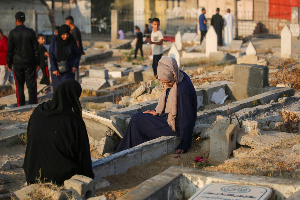 Palestinos visitam os túmulos de seus entes queridos no primeiro dia do festival muçulmano Eid al-Adha em Nuseirat, no centro da Faixa de Gaza, em 6 de junho de 2025, em meio à guerra entre Israel e o Hamas. (Foto de Eyad BABA / AFP)
