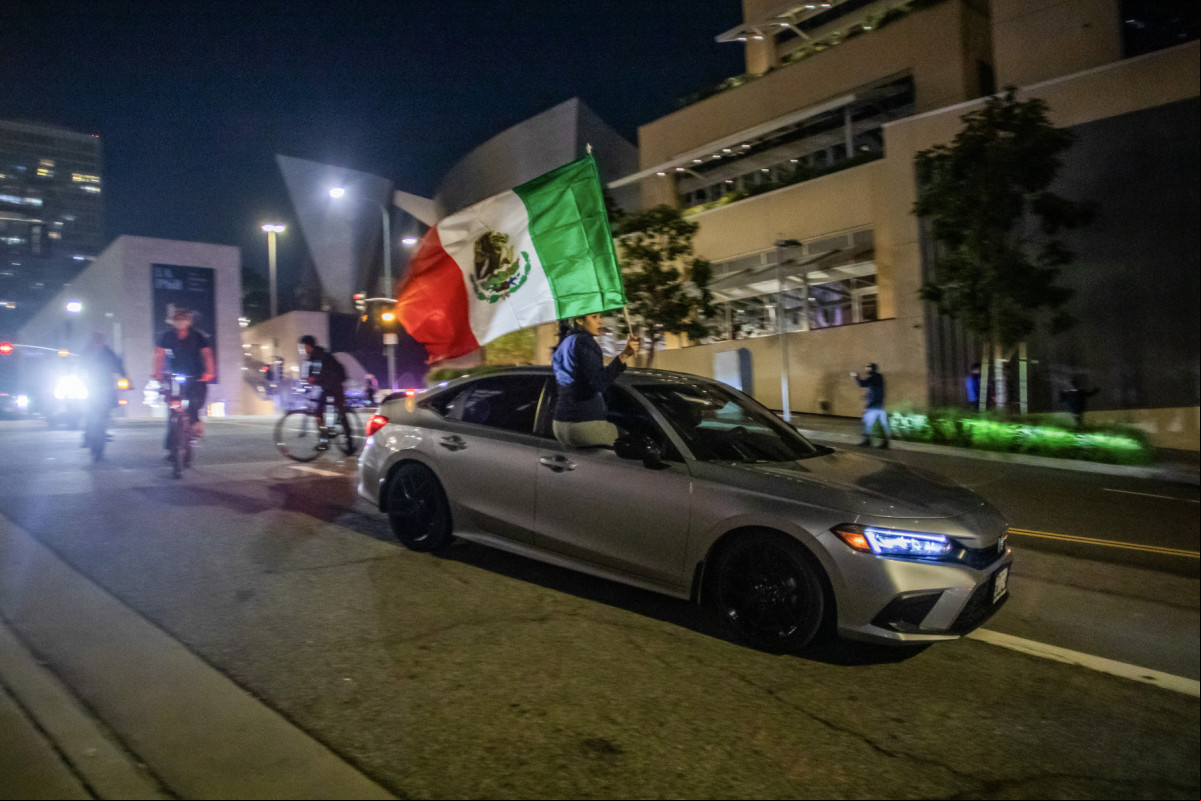 Manifestantes em carros e bicicletas são vistos no centro da cidade, apesar do toque de recolher imposto após dias de protestos em resposta às operações federais de imigração em Los Angeles, em 10 de junho de 2025. A polícia de Los Angeles começou a prender pessoas no centro da cidade na noite de 10 de junho, enquanto grupos se reuniam em violação ao toque de recolher noturno após o quinto dia de protestos contra a repressão imigratória de Donald Trump. (Foto de Apu GOMES / AFP) ( AFP) Manifestantes em carros e bicicletas são vistos no centro da cidade, apesar do toque de recolher imposto após dias de protestos em resposta às operações federais de imigração em Los Angeles, em 10 de junho de 2025. A polícia de Los Angeles começou a prender pessoas no centro da cidade na noite de 10 de junho, enquanto grupos se reuniam em violação ao toque de recolher noturno após o quinto dia de protestos contra a repressão imigratória de Donald Trump. (Foto de Apu GOMES / AFP)/ AFP